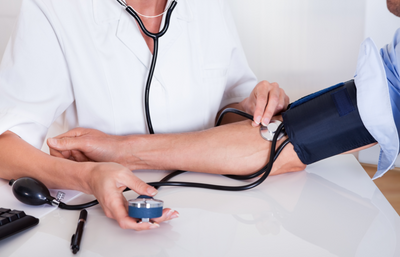 Doctor Taking Blood Pressure Reading with BP Monitor